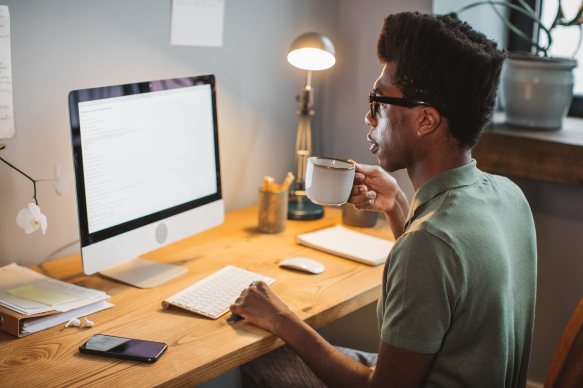 Young man at home office working on computer.
